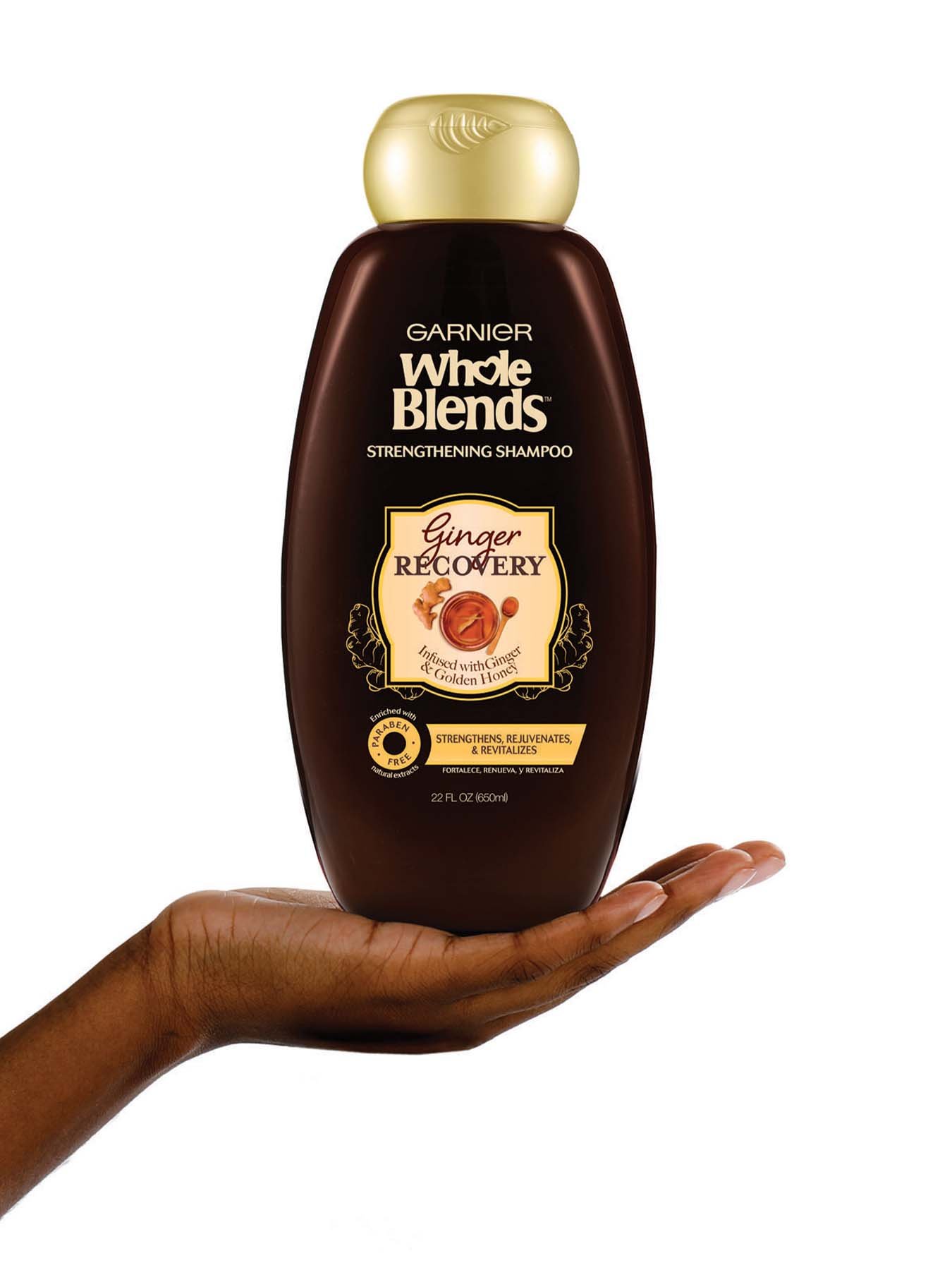 Hand holding Whole Blends Ginger Recovery Strengthening Shampoo 22oz.